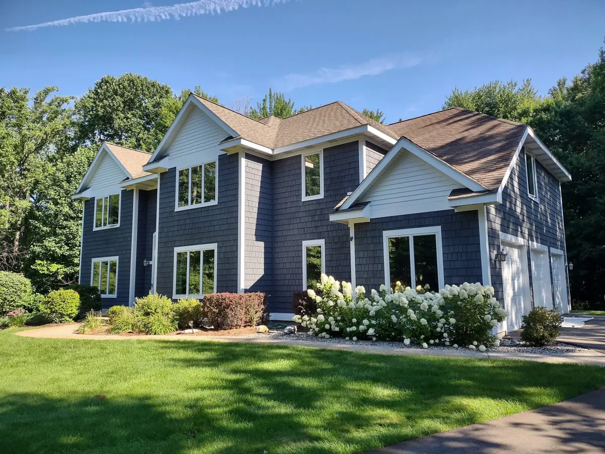 Two-story home with dark gray shake siding and crisp white trim